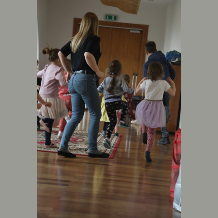 Na zdjęciu znajduje się grupa dzieci razem z prowadzącą warsztaty taneczne.
