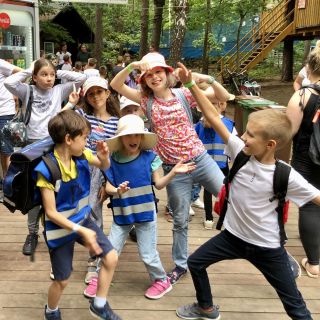 Zdjęcie przedstawia grupkę dzieci bawiących się na półkolonii