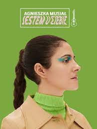 Na zdjęciu artystka na tle zielonego tła.