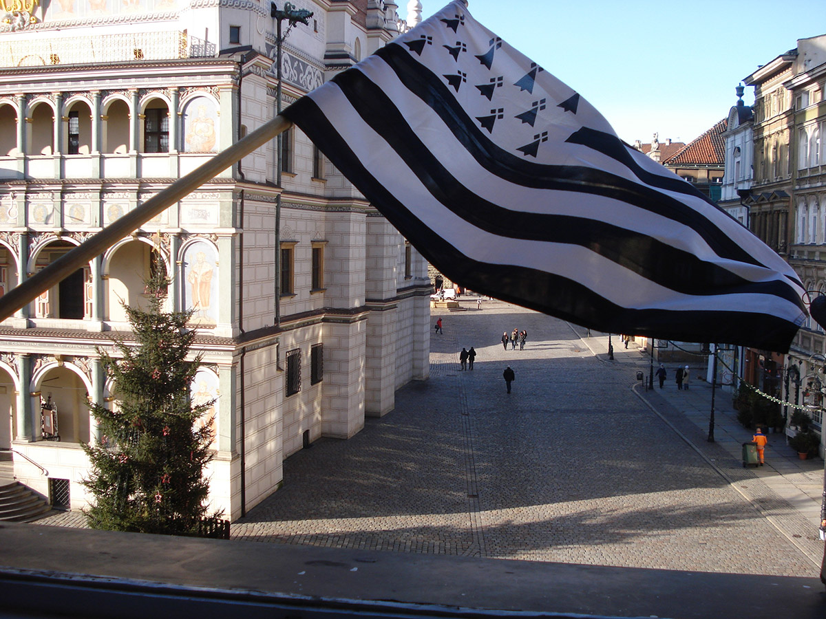 Białoczarna flaga Bretanii powiewająca na tle Ratusza Poznańskiego
