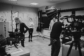 kilkoro ludzi na planie filmowym w kolorach czarnym i białym