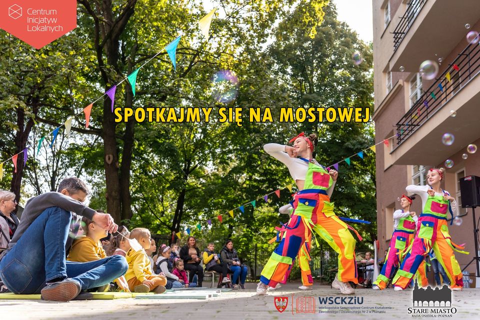 Kolorowo ubranie artysci przed widownią na tle zielonych drzew