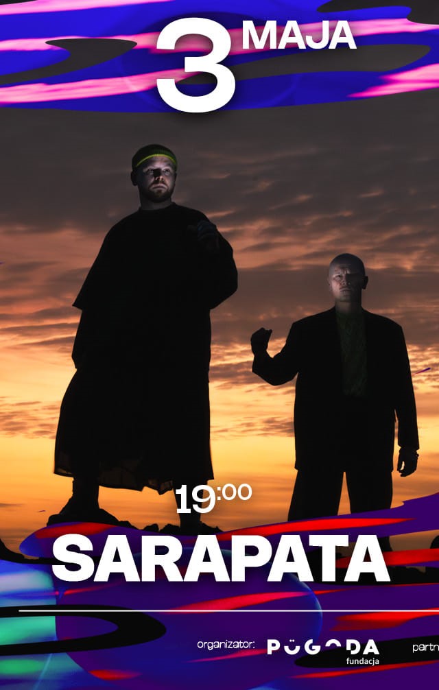 zdjecie 2 wykonawców na tle zachodzącego słońca