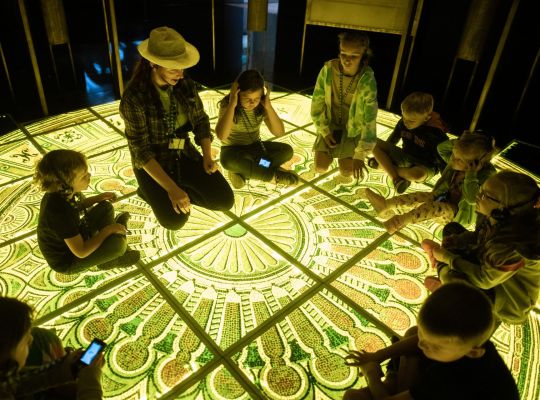 Zdjecie przewodnika z dziećmi wewnątrz muzeum