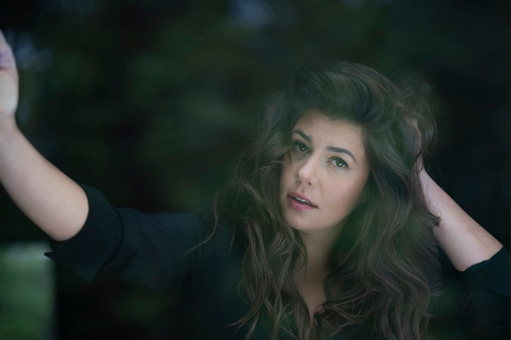 Monika Borzym pozuje do zdjęcia z dłonią wplątaną we włosy.