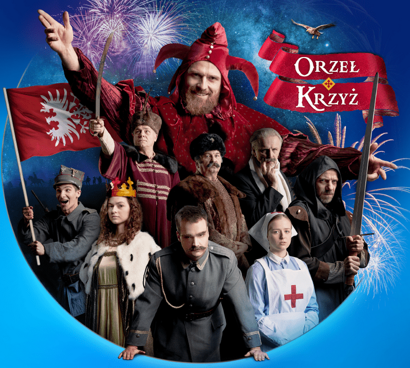 na zdjęciu grupa osób w kostiumach historycznych z różnych okresów, za nimi widoczna największa postać - Stańczyk w czerownym stroju błazna