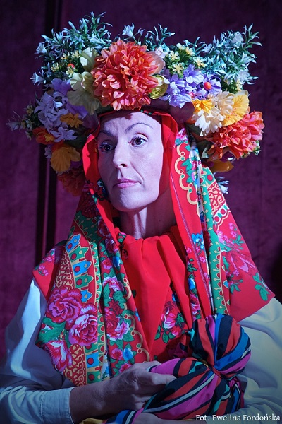 Zdjęcie kobiety w kolorowej chuście i wianku na głowie.