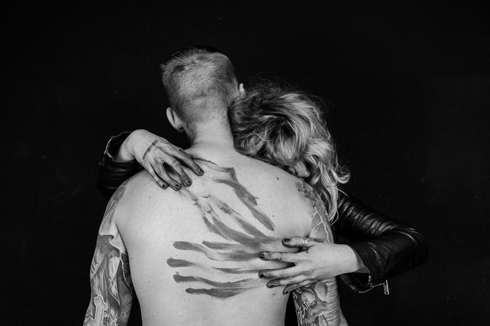 Czarno-białe zdjęcie kobiety obejmującej mężczyznę, twarze kobiety i mężczyzny są niewidoczne.