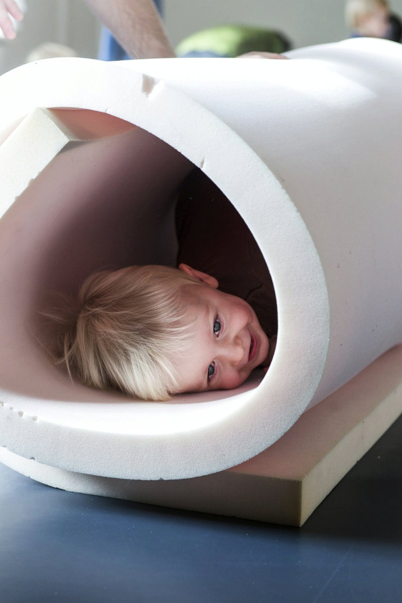 Zdjęcie uśmiechniętego dziecka w tubie z gąbki.