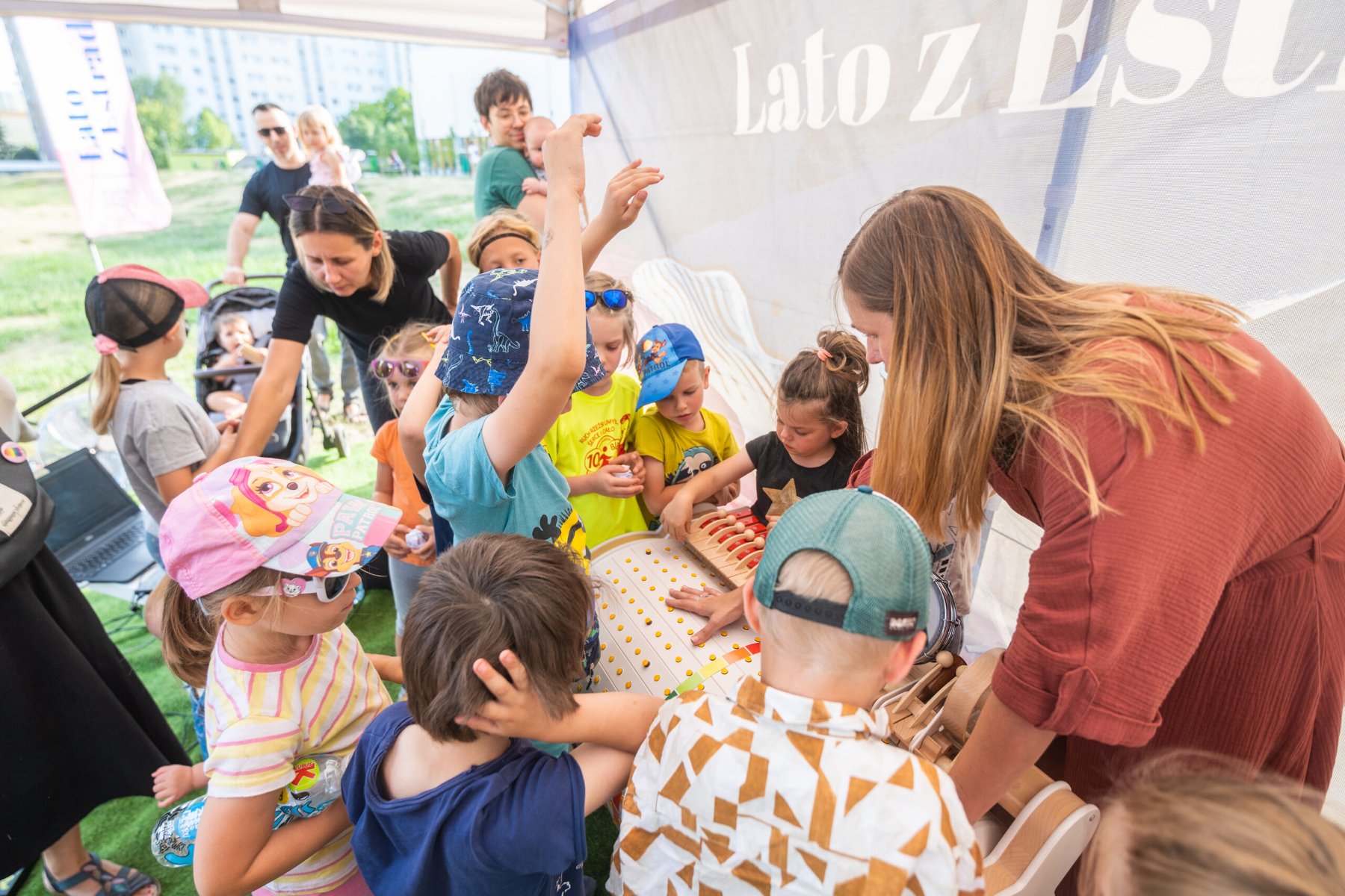 Na zdjęciu znajduje się grupa dzieci, która bawi się przy zabawce.