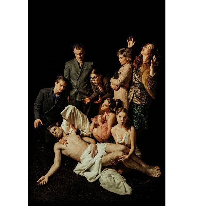 zdjecie przedstawia leżącą postać nagiego mężczyzny przepasanego szatą, kobieta w chuście pochylon trzyma jego głowę na ramieniu, obok niej i za nią postaci mężczyzn i kobiet