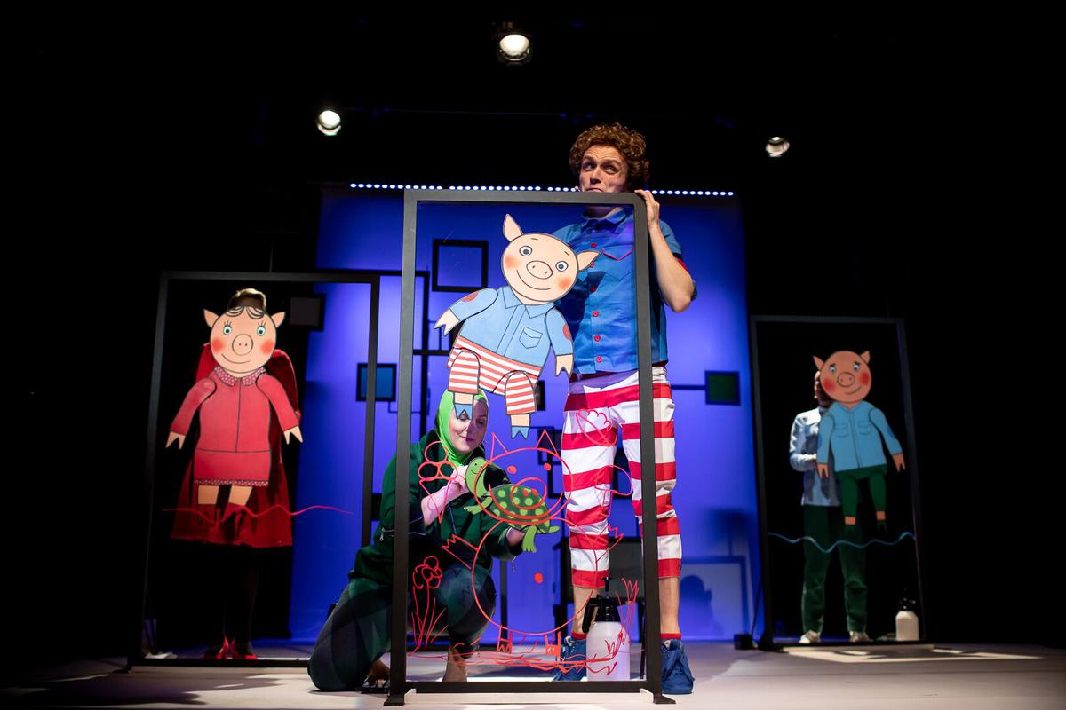 Zdjęcie przedstawiające aktorów na scenie z lalkami bohaterów przedstawienia.