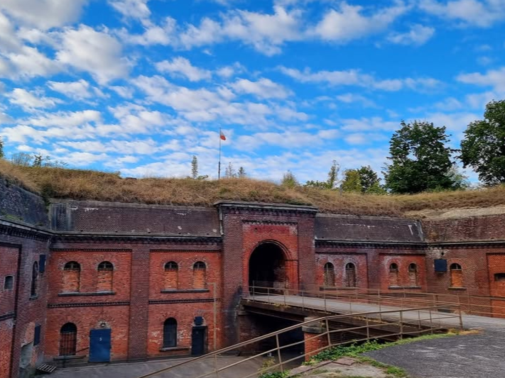 Wejście do starego, wojskowego fortu przez kładkę przewieszoną nad suchą fosą.