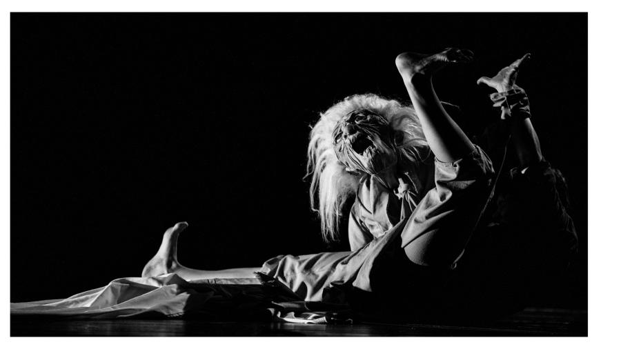 "Trzy ćwierci do śmierci", fot. fot. HaWa Przewrócona postać. Zamiast głowy żywego aktora jest głowa lalki/staruszki z potarganymi siwymi głowami.